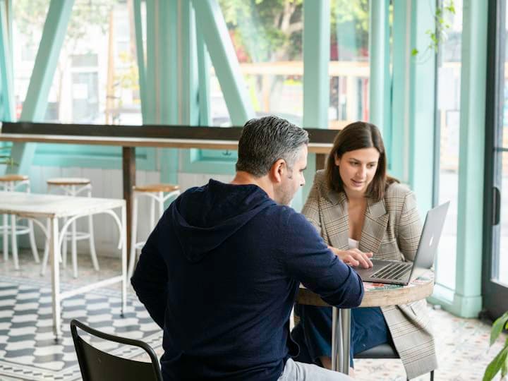 Deux personnes en rendez-vous devant un ordinateur